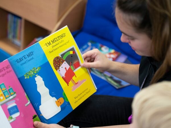 Student reading to child in nursery