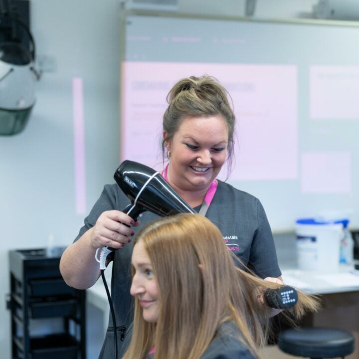 Adult student drying clients hair