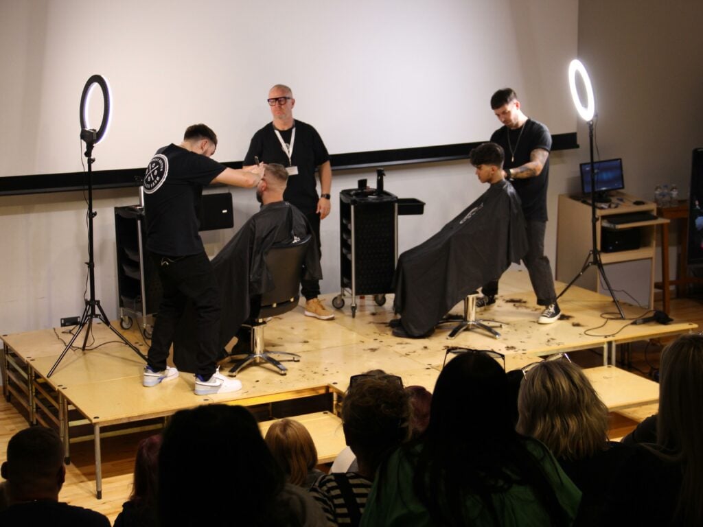 Men barbering on stage at the Barber Bash Show