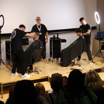 Men barbering on stage at the Barber Bash Show