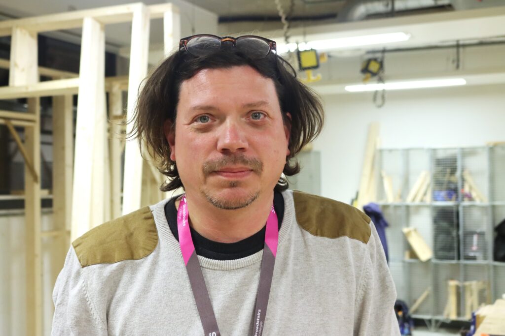 adult learner smiling at camera in the workshop.