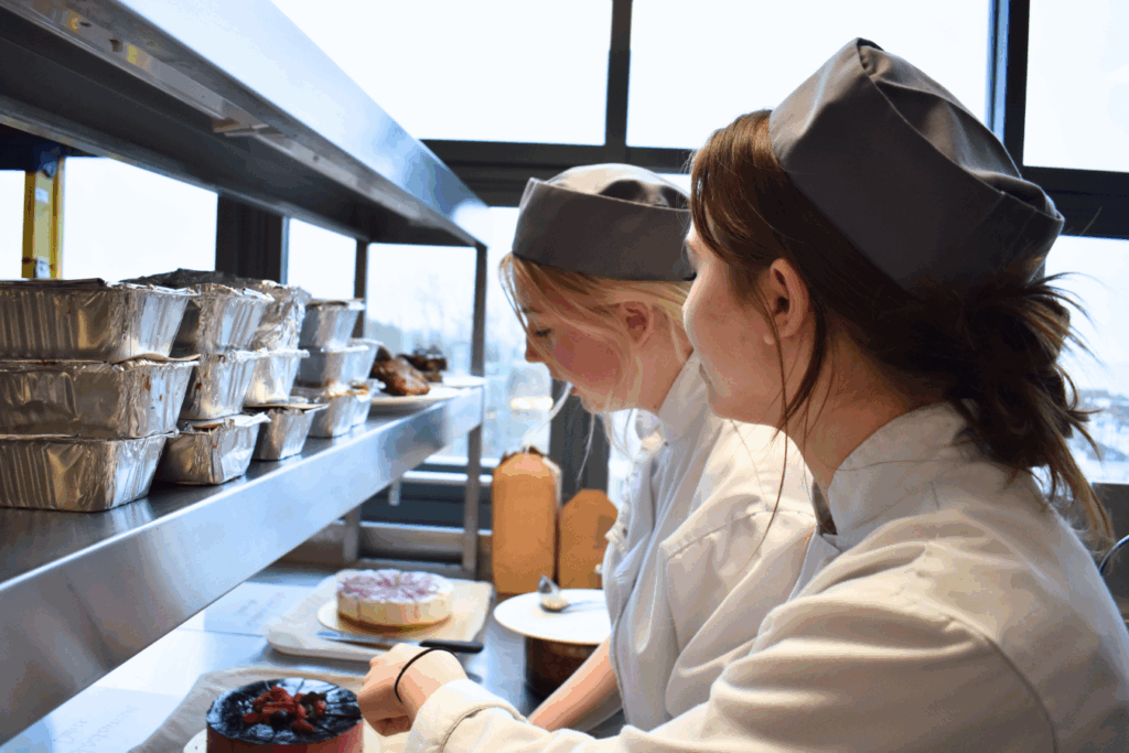 two catering students look at patisserie items