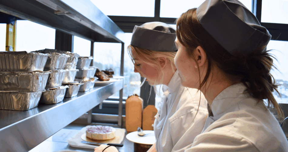 two catering students look at patisserie items