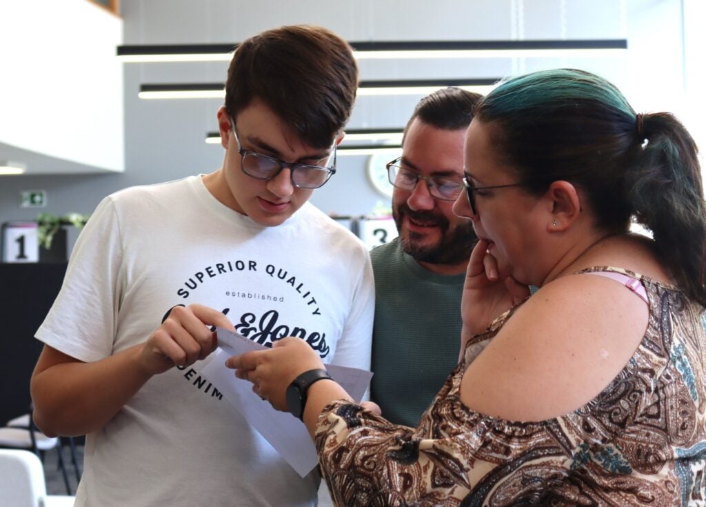computing student looks at his results with his parents