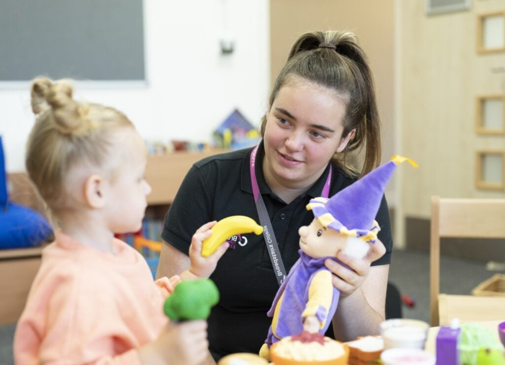 childcare college student interacts with child