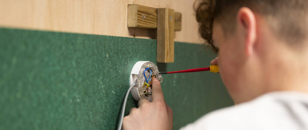 student close up using a screwdriver on a socket.