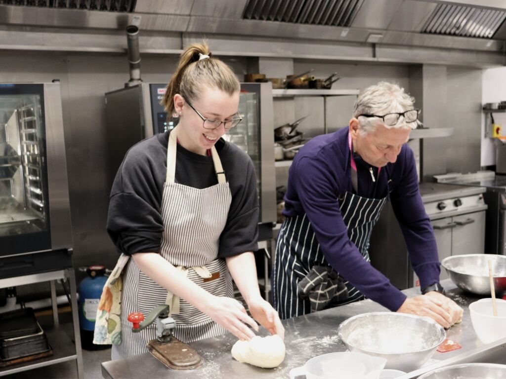 two adult students learning in a cookery class