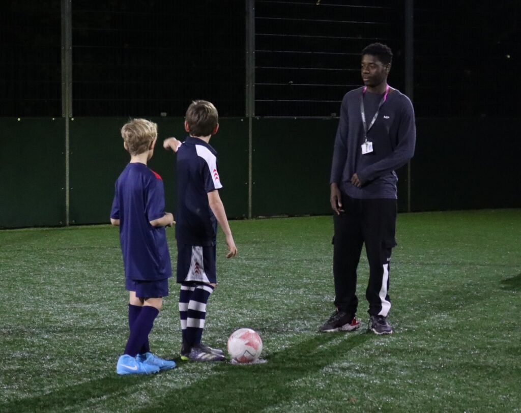 2 young footballers with a coach