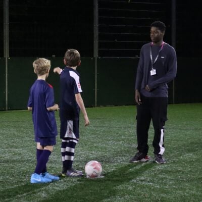 2 young footballers with a coach