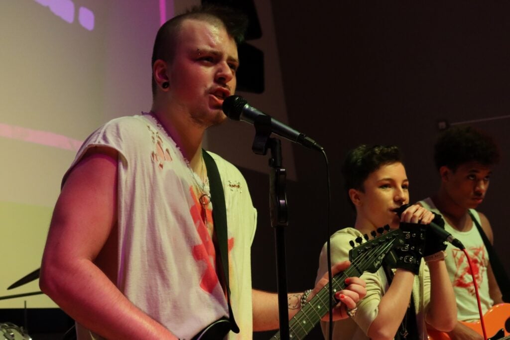 Hayden performs on stage in a punk show