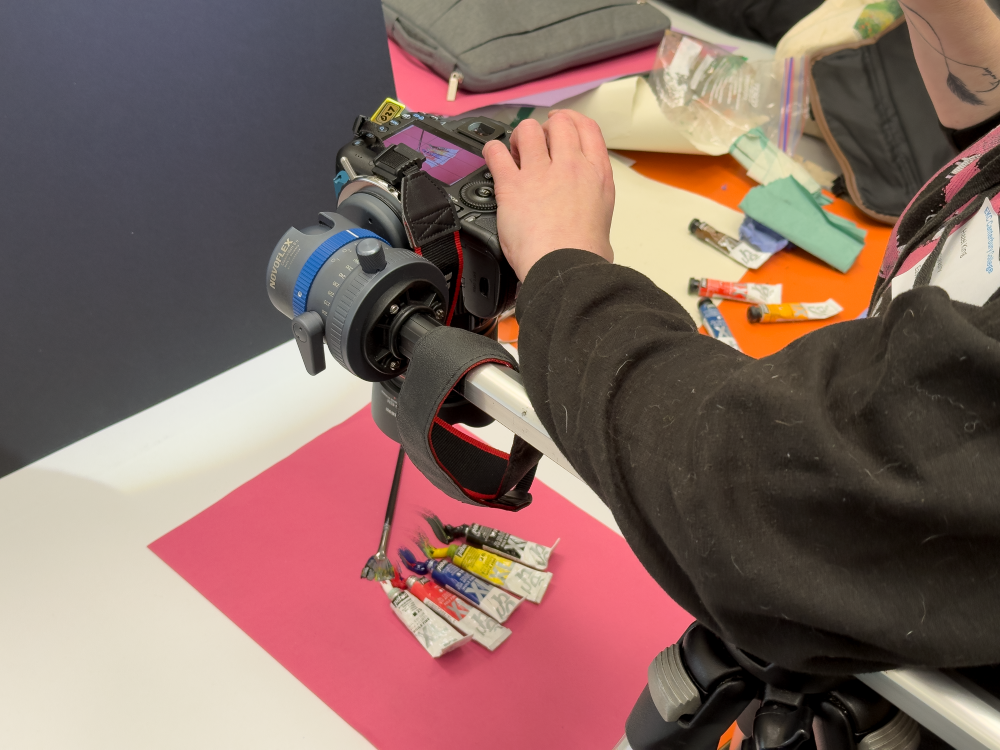 Student taking a photo of oil paint