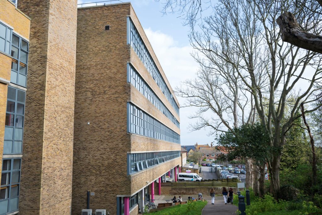 the side of a building showing the college campus