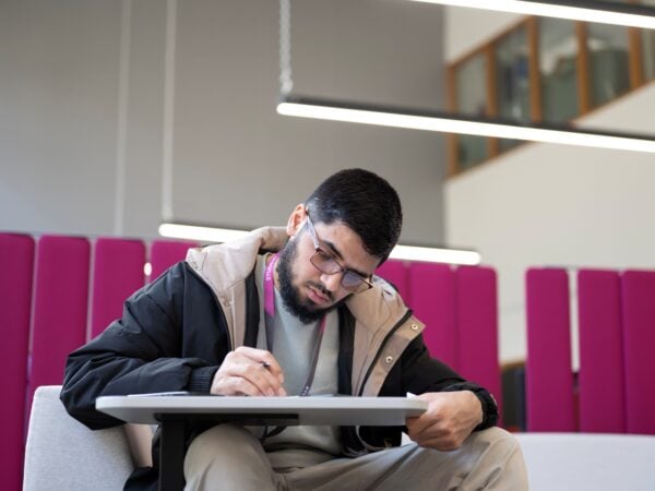man sat at a desk writing