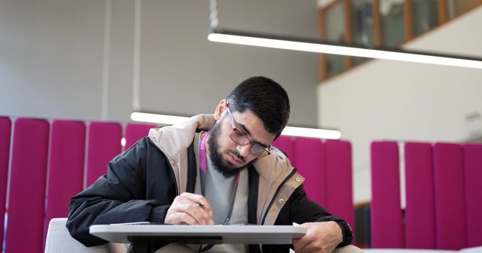 man sat at a desk writing