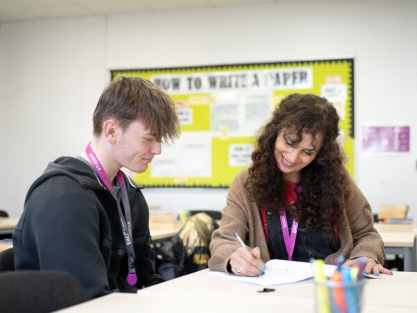 tutor marking students work smiling
