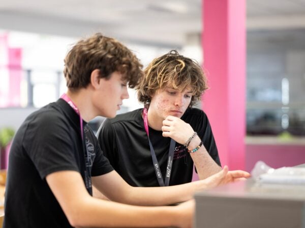 Two students sat down looking at some work