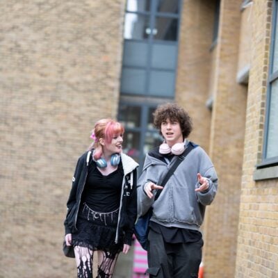 2 students walking away from a college building