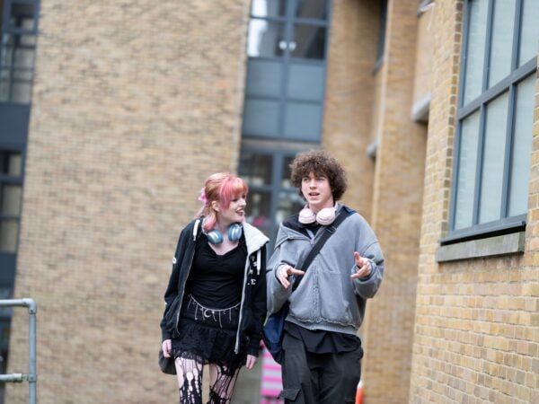 2 students walking away from a college building