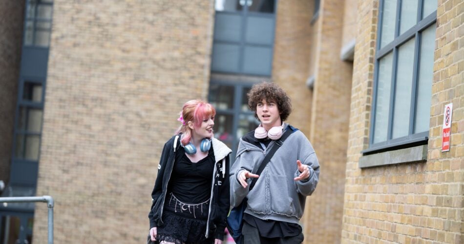 2 students walking away from a college building
