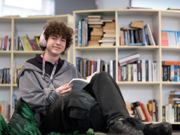 student sat on a bean bag reading a book