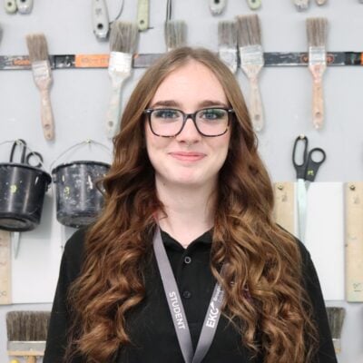 Student in a workshop smiling at the camera