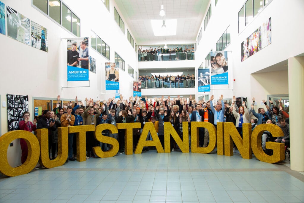 Outstanding letters with students stood behind cheering.