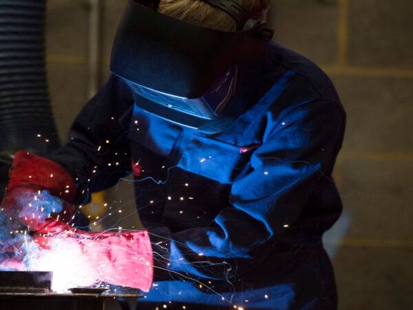 A welding student welding with sparks flying