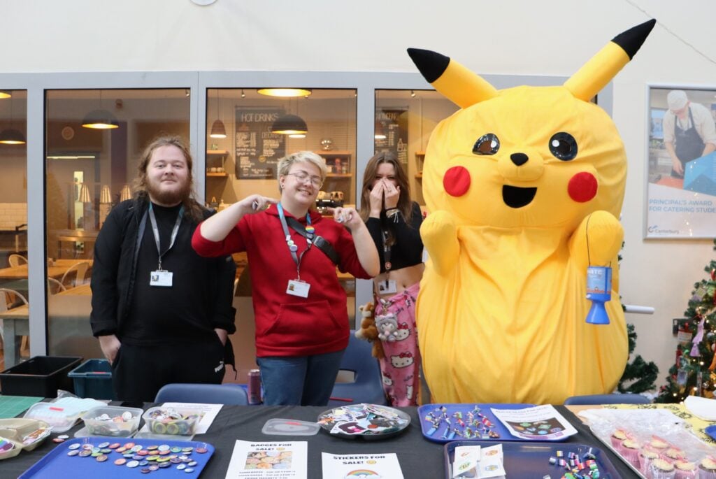 Students stood smiling at the badge stall