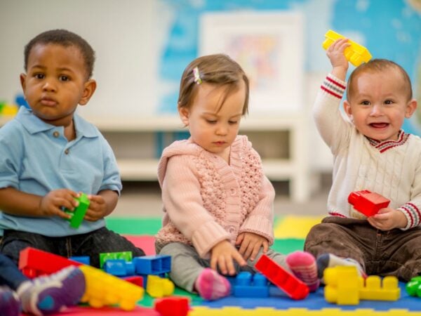 3 small children playing with building blocks