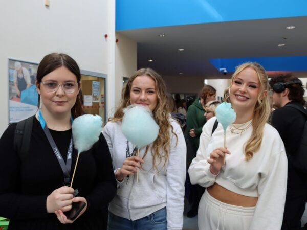 Three students holding candyfloss