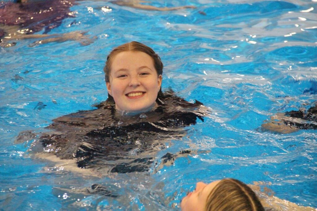 Student in swimming pool smiling
