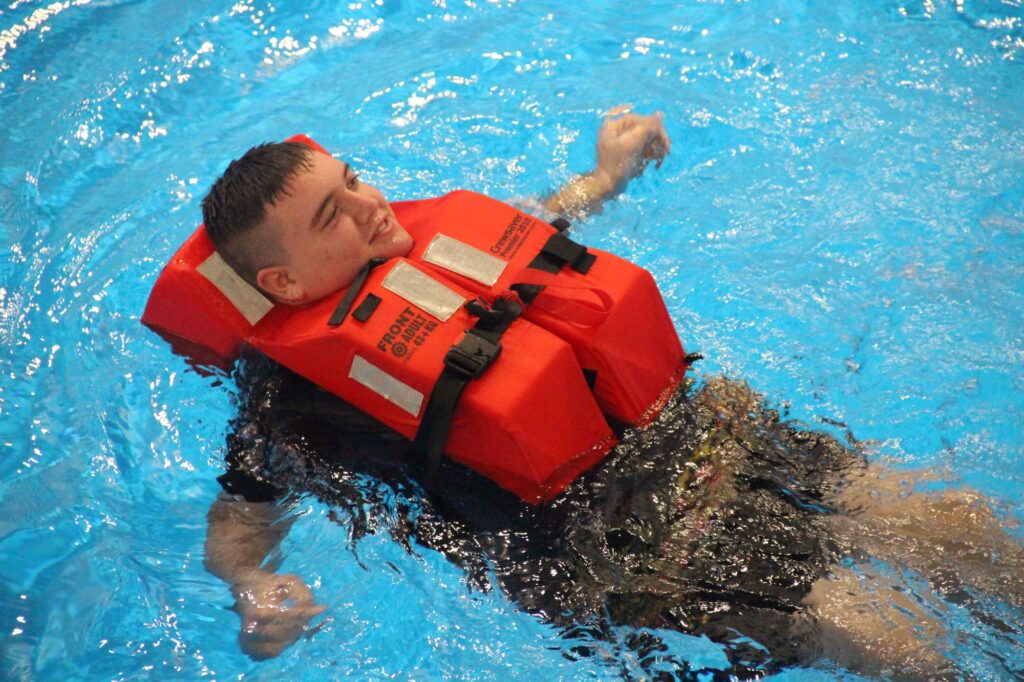 Students with life jacket floating in a pool