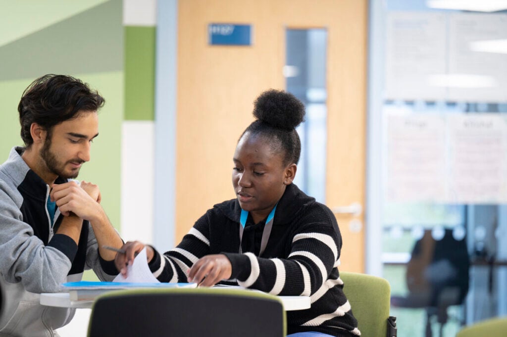 2 students sat at a desk working