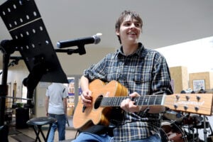 student playing music on guitar at freshers fair
