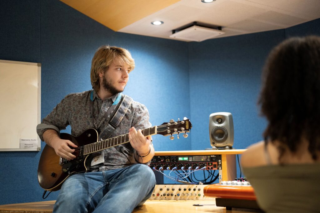 Student sat down playing guitar