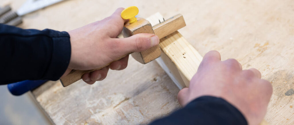 Student working with wood on a workbench