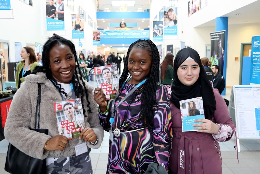 Three students smiling a camera