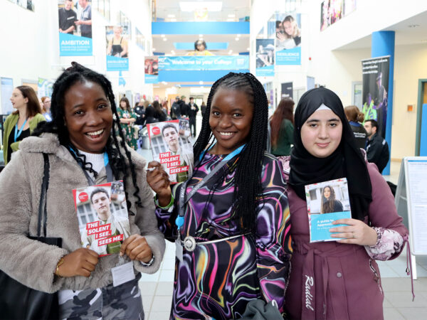 Three students smiling a camera