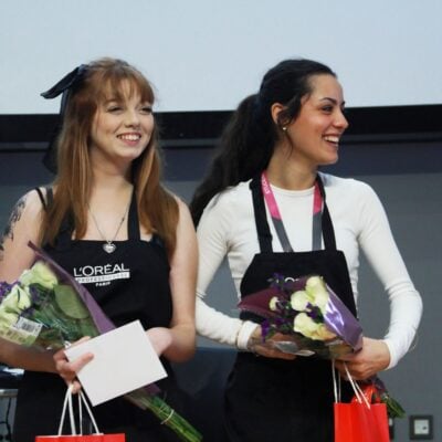 Two hairdressing students holding flowers