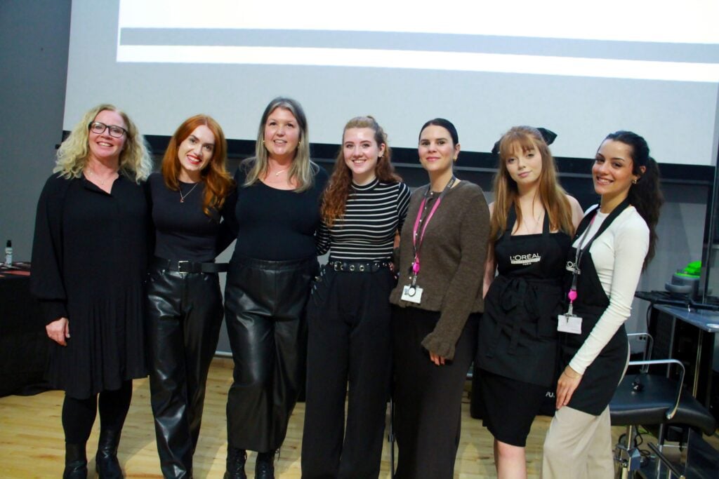 Seven ladies standing in a line smiling