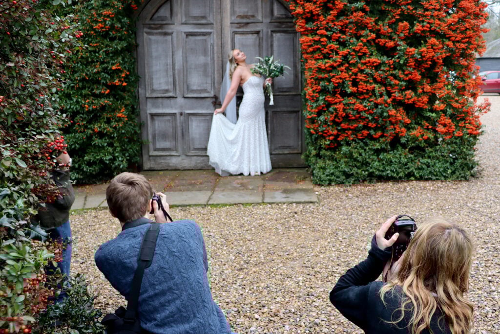 Two students taking photos of model bride