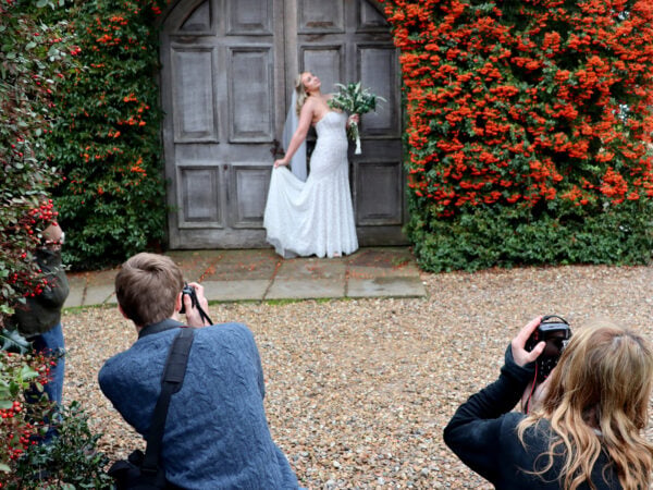 Two students taking photos of model bride