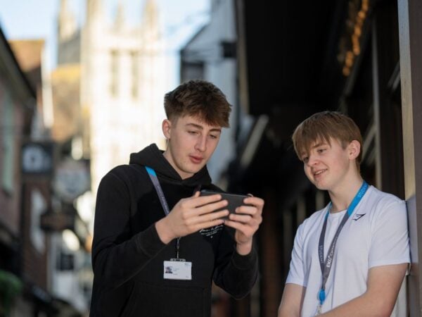 EKC Canterbury College students in Canterbury looking at a phone