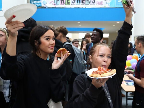 Students celebrate with pizza at EKC Canterbury College Freshers Fair