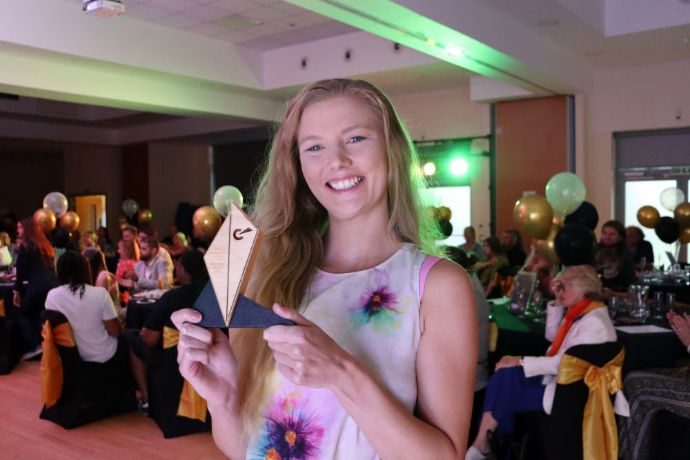 Lady smiling at camera holding a trophy