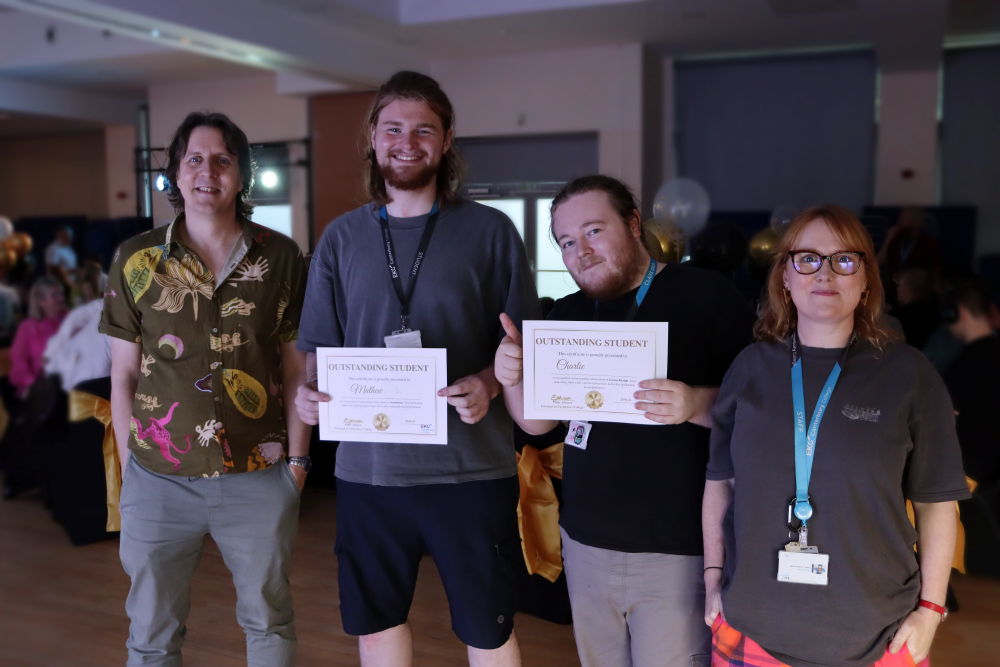Two students with awards standing next to tutors