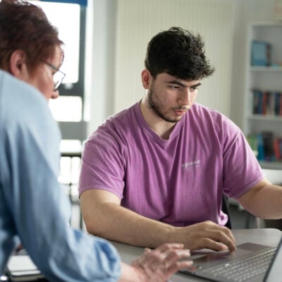 A teacher is helping student with their work