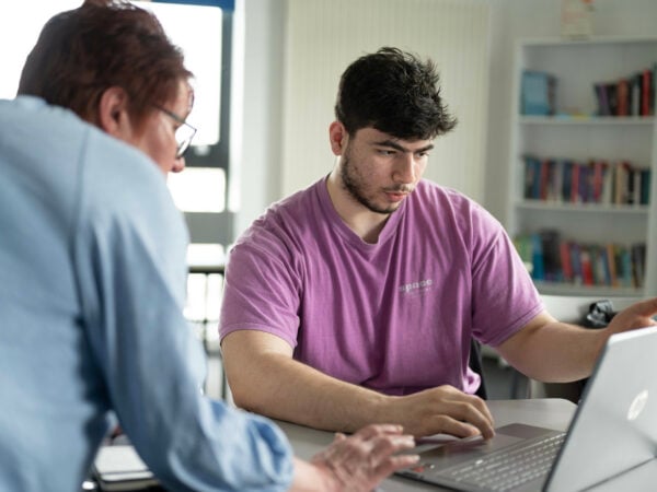 A teacher is helping student with their work