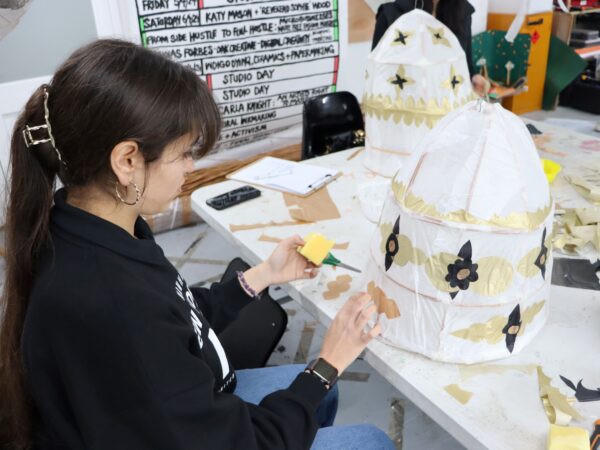 Student using tissue paper to decorate paper lantern