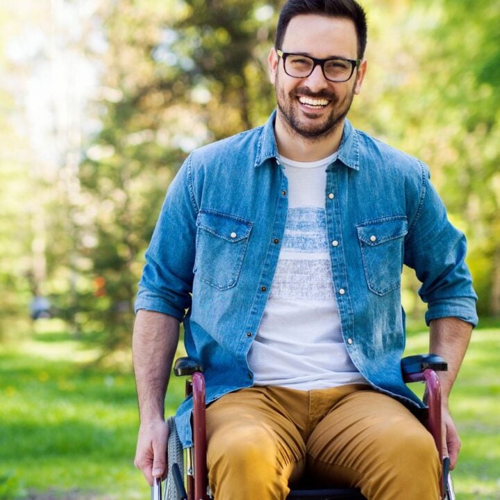 Man in a wheelchair smiling at the camera.